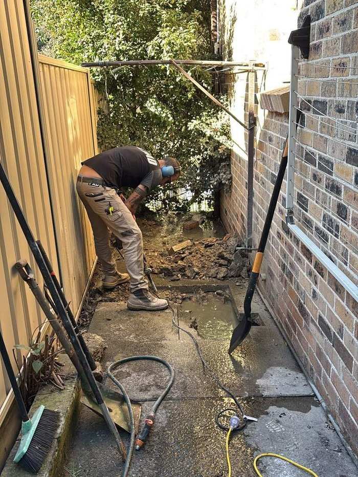 Anthony repairing the drainage pipe in the trench