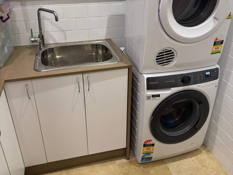 Finished laundry with sink, washer and dryer stacked